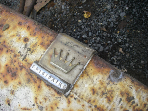 A photo of a rusty Frigidaire logo